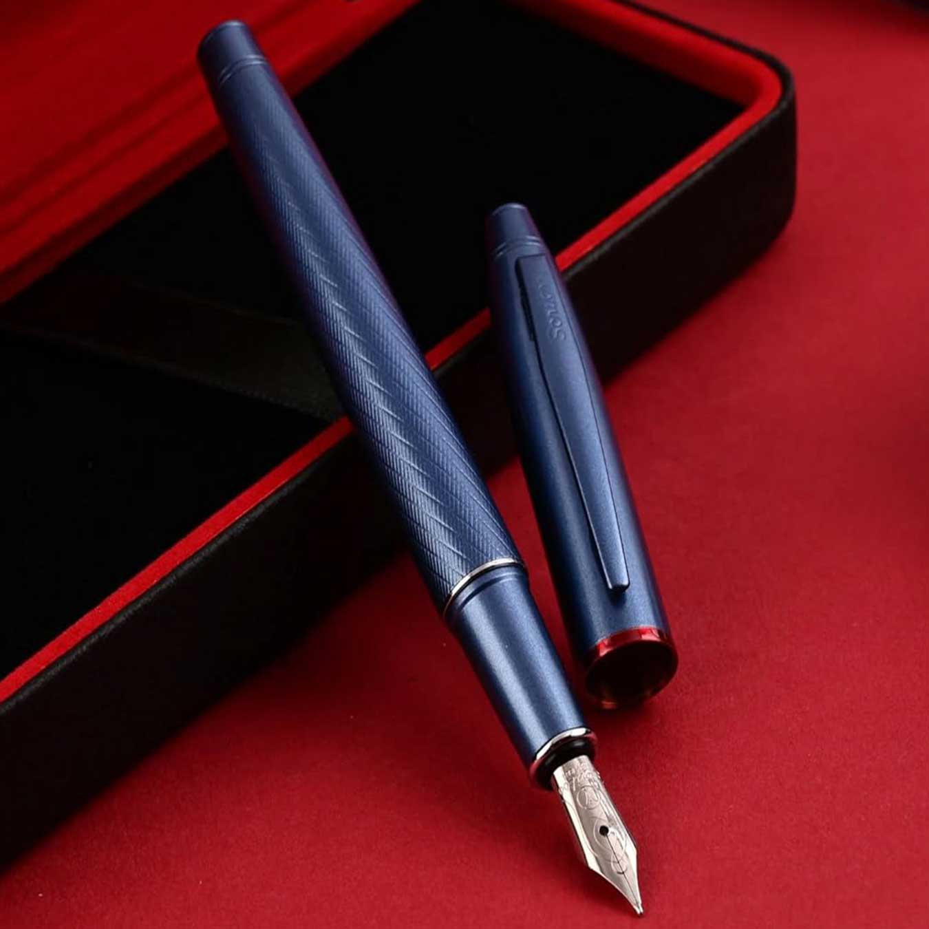 Scrikss Noble 35 Medium nib Blue fountain pen with cap on a red surface