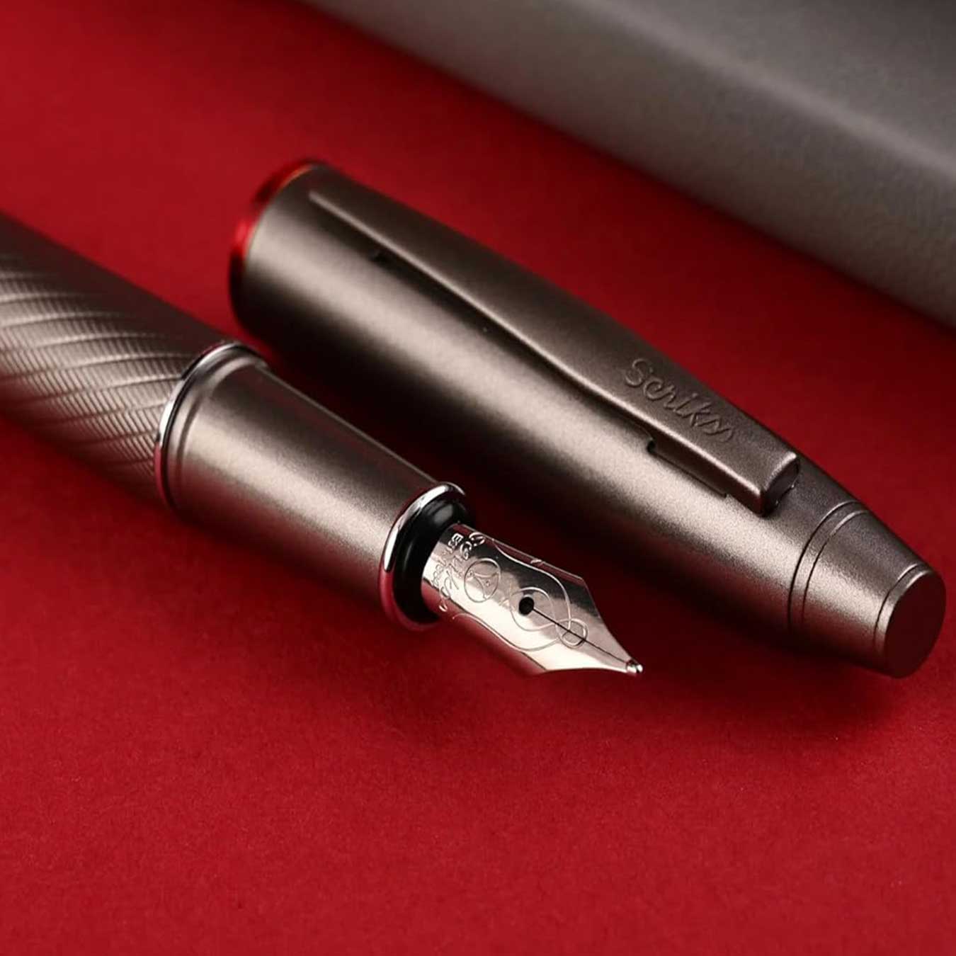 scrikss noble 35 medium nib Fountain pen with detailed design on a red surface
